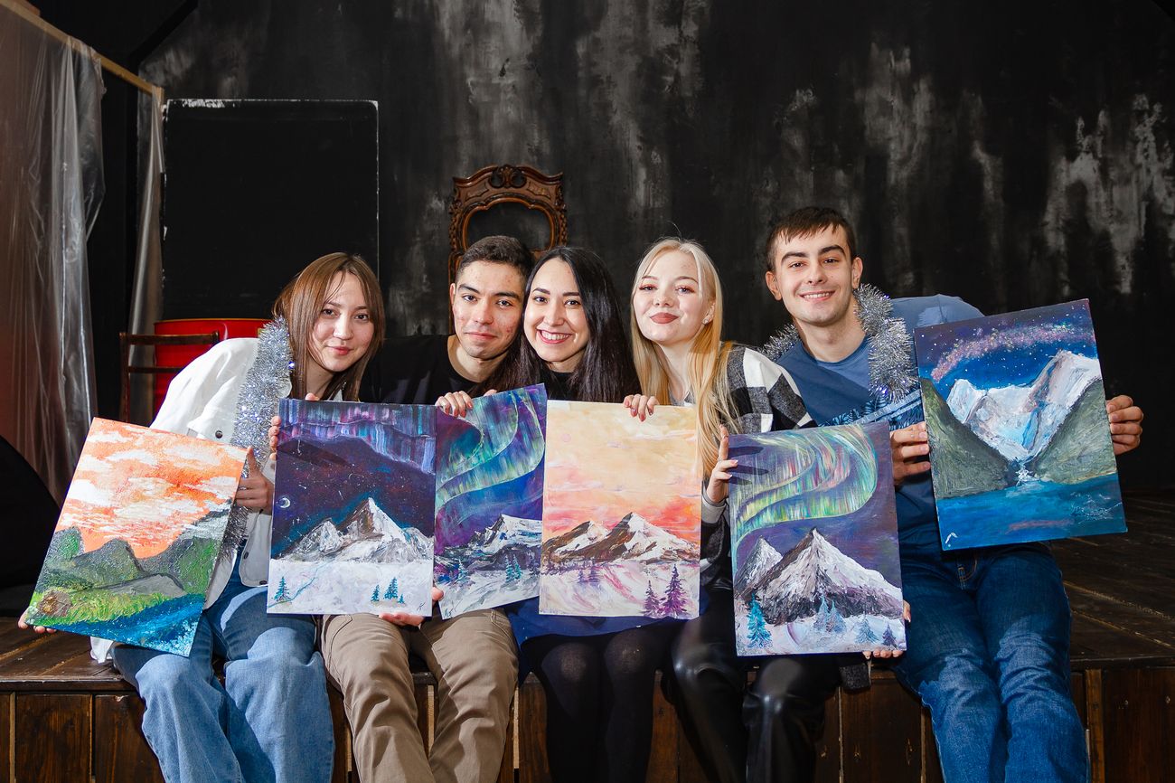 Five workshop students holding their northern-lights mountain paintings